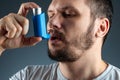 Portrait of a man with an asthma inhaler in his hands, an asthmatic attack. The concept of treatment of bronchial asthma, cough, Royalty Free Stock Photo