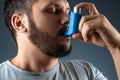 Portrait of a man with an asthma inhaler in his hands, an asthmatic attack. The concept of treatment of bronchial asthma, cough,