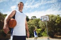 Portrait of man with basketball with friend playing in background Royalty Free Stock Photo