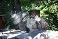 Portrait of man beekeeper working in apiary, holding bee smoker. Royalty Free Stock Photo