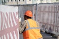 Portrait of a man from behind in a construction, orange helmet against the background of a construction site. Concept architecture Royalty Free Stock Photo