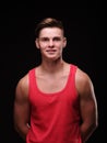 Portrait of a man on a black background in a red tank top. Royalty Free Stock Photo
