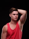 Portrait of a man on a black background in a red tank top. Royalty Free Stock Photo