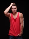 Portrait of a man on a black background in a red tank top. Royalty Free Stock Photo