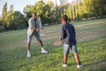 Portrait of man and boy playing badminton on green field Royalty Free Stock Photo