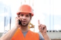 Portrait of man builder in hardhat working at construction site, talking on phone. Construction worker on construction Royalty Free Stock Photo