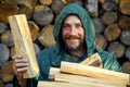 Portrait of a man with a bunch of chopped firewood. Bearded lumberjack with firewood for the fireplace. Royalty Free Stock Photo