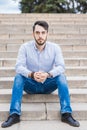 Portrait of a man businessman with a beard who sits on the steps. Royalty Free Stock Photo