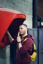 Portrait of a man calling a pay phone in a loft space. Translation: pay phone. Royalty Free Stock Photo