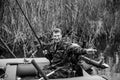 Portrait of man catching fish on the lake. Black and white photo. Royalty Free Stock Photo