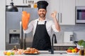 Portrait of man in chef apron and cook hat preparing fresh natural meal salmon at kitchen. Handsome cheerful chef man Royalty Free Stock Photo