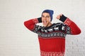 Portrait of man in Christmas sweater and hat near  brick wall Royalty Free Stock Photo