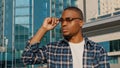 Portrait of man in city african american guy young student man in stylish sunglasses wears plaid shirt looks away to Royalty Free Stock Photo