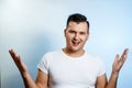 Portrait of a man close-up, who is surprised to spread his hands. On a light background. The concept of human emotions Royalty Free Stock Photo