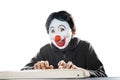 Portrait of man in clown mask typing on desktop Royalty Free Stock Photo