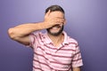 Portrait of man covering eyes with hand on color background Royalty Free Stock Photo