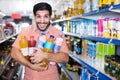Portrait of man customer who is standing with drinks in supermarket. Royalty Free Stock Photo