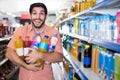 Portrait of man customer who is standing with drinks in supermarket. Royalty Free Stock Photo