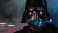 Portrait of a man in a Darth Vader mask. He raises his hand up, using telekinesis, the power of a Jedi. Steam on the