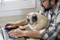 Portrait of man and dog working together at home with laptop computer - concept of free smart work lifestyle people - caucasian Royalty Free Stock Photo