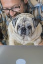 Portrait of man and dog working together at home with laptop computer - concept of free smart work lifestyle people - caucasian Royalty Free Stock Photo