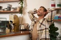 Portrait of man doing big stretch with satisfied smile, finishing his project, sitting in cafe with laptop and phone Royalty Free Stock Photo