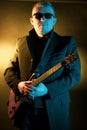 Portrait of a man with an electric guitar in his hands, made in a photo studio using color filters Royalty Free Stock Photo