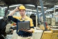 Portrait of Man engineer wear yellow hard hat and wearing safety uniform standing at forklift holding laptop working at heavy