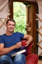 Portrait Of Man Enjoying Luxury Camping Holiday In Yurt