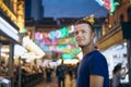 Portrait of man on evening illuminated street market