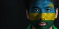 Portrait of a man with the flag of the Rwanda painted on his face on black background.