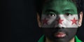 Portrait of a man with the flag of the Syrian Interim Government painted on his face on black background. Royalty Free Stock Photo