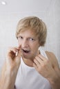 Portrait of man flossing teeth in bathroom Royalty Free Stock Photo