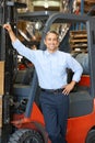 Portrait Of Man With Fork Lift Truck In Warehouse Royalty Free Stock Photo