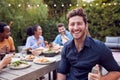 Portrait Of Man With Friends At Home Sitting At Table Enjoying Food At Summer Garden Party Royalty Free Stock Photo