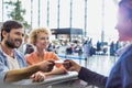 Portrait of man giving passport to passenger service agent to get his boarding pass in airport Royalty Free Stock Photo