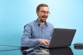 Portrait of man in glasses and checkered shirt, computer geek, programmer isolated over blue background Royalty Free Stock Photo