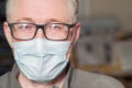 Portrait of a man with glasses and a medical mask. The concept of protection and prevention of viral and infectious diseases.