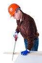 Portrait of man in helmet sawing plank of wood Royalty Free Stock Photo