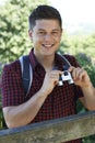 Portrait Of Young Man Hiking In Countryside Looking Through Binoculars Royalty Free Stock Photo