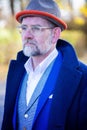 Portrait of man in his 50s in blue suit and coat outdoors Royalty Free Stock Photo