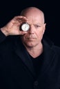Portrait of man in his 50s holding pocket watch to his eye Royalty Free Stock Photo