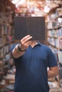 Portrait of a man holding a black book at the level of the face. The book is in focus Royalty Free Stock Photo