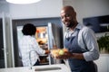 Portrait of man holding bowl of salad while woman opening a refrigerator in background Royalty Free Stock Photo