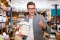 Portrait of man holding stack of books in hands in bookshop Royalty Free Stock Photo