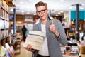 Portrait of man holding stack of books in hands in bookshop Royalty Free Stock Photo