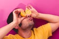 Portrait of a man holding two sliced lemons in his eyes Royalty Free Stock Photo
