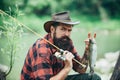 Portrait of man on holiday. Fishing background. Fly fishing adventures. Man dressed in shirt fishing with rod on the Royalty Free Stock Photo