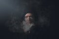 Man in hoodie with smoke in front of his face