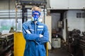 Portrait of man industrial worker wearing chemical protective mask and uniform arms crossed standing at industrial factory. Royalty Free Stock Photo